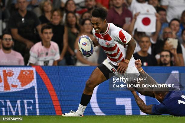 Japan's right wing Kotaro Matsushima is tackled by Samoa's right wing Ed Fidow as he runs with the ball during the France 2023 Rugby World Cup Pool D...
