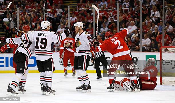 Bryan Bickell of the Chicago Blackhawks reacts to his third period goal with Jonathan Toews and Marian Hossa in front of Jimmy Howard and Brendan...