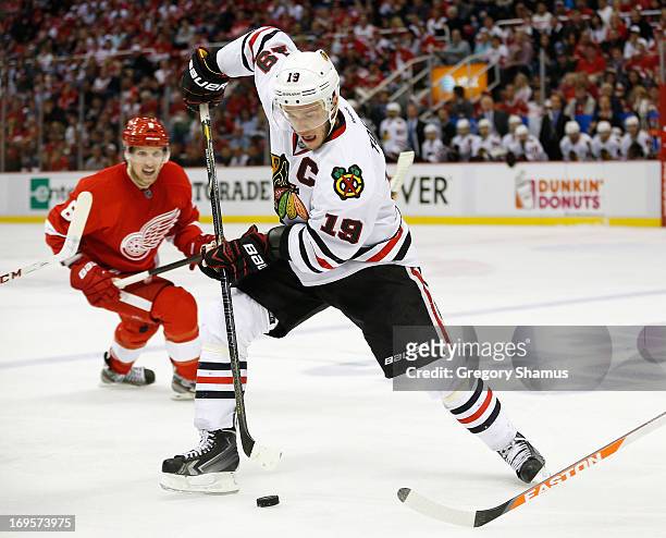 Jonathan Toews of the Chicago Blackhawks tries to control the puck in front of Justin Abdelkader of the Detroit Red Wings in Game Six of the Western...