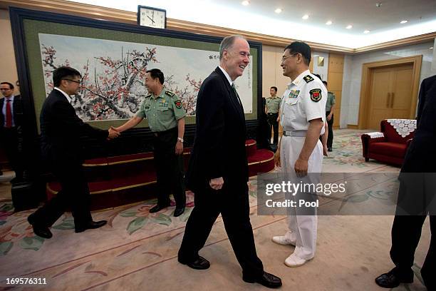 National Security Adviser Tom Donilon walks to his seat while Vice Chairman of China's Central Military Commission, General Fan Changlong shakes...