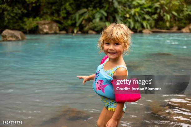 a young girl playing in a blue river in costa rica - water wings stock pictures, royalty-free photos & images