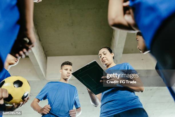 soccer woman coach talking with players on the soccer field - physical education stock pictures, royalty-free photos & images