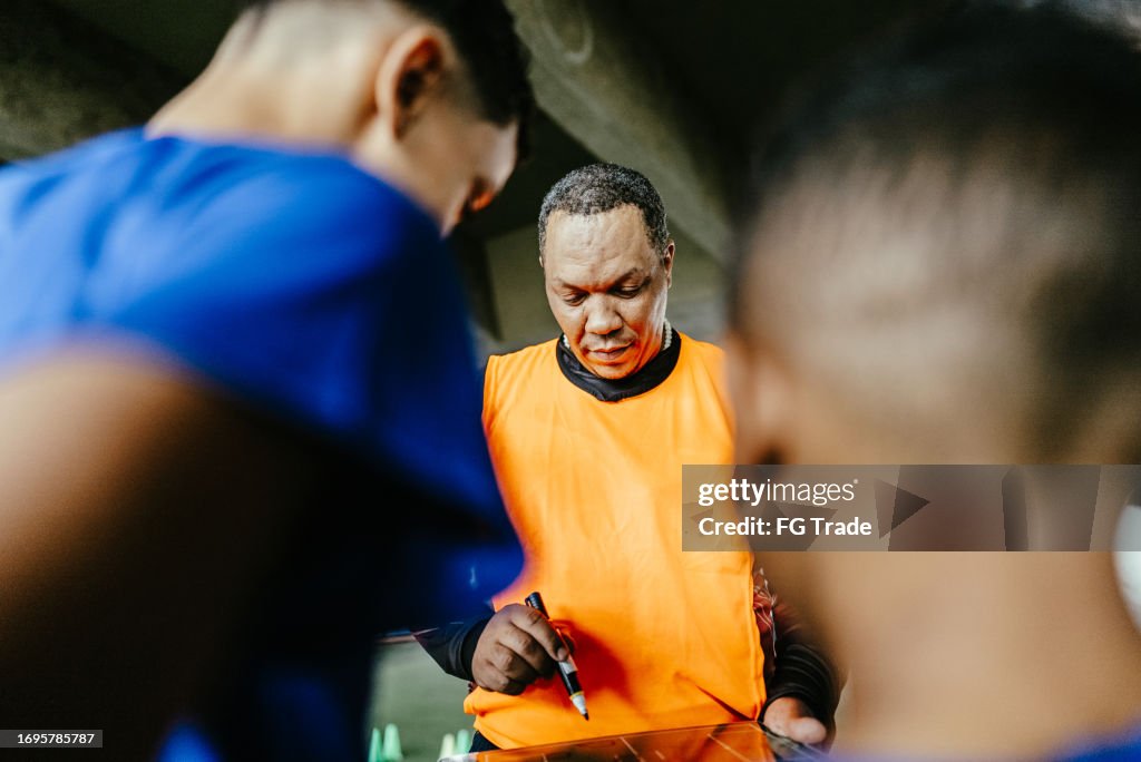 Soccer coach talking with players on the soccer field