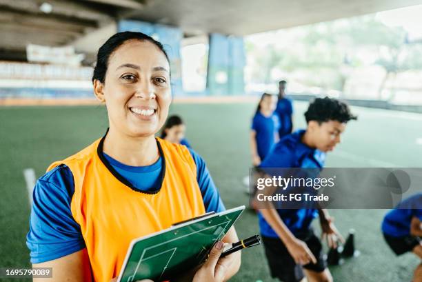 portrait d’une entraîneuse de football sur le terrain de football - éducation physique photos et images de collection