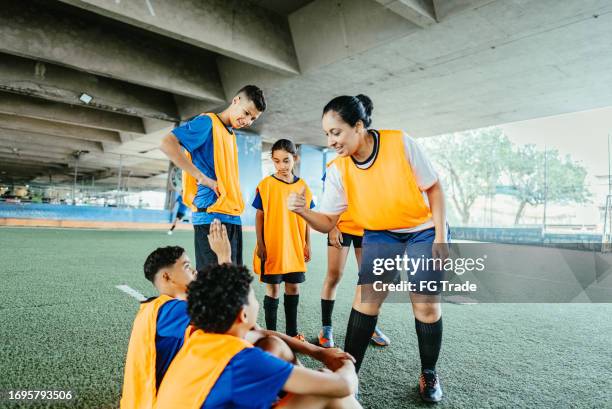 soccer woman coach doing thumbs up to player on the soccer field - youth sports training stock pictures, royalty-free photos & images