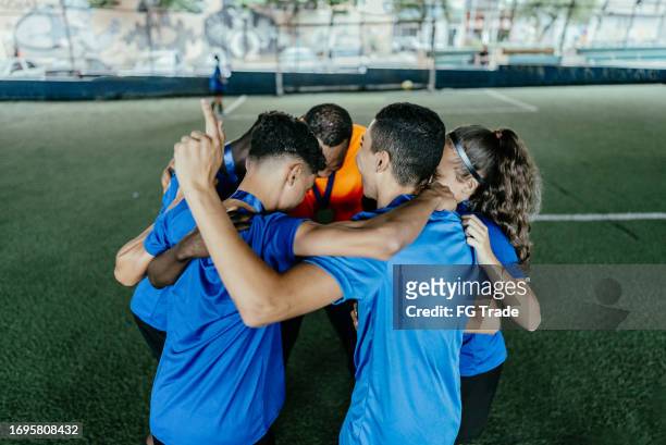 soccer team huddling after win the soccer match - sport determination stock pictures, royalty-free photos & images