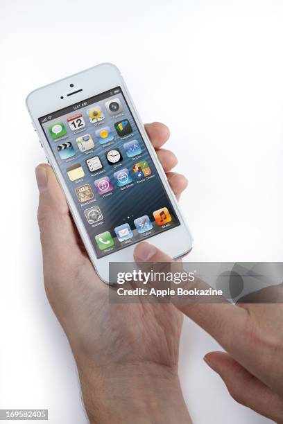 This image has been digitally manipulated) A close-up of a man's hands using a white Apple iPhone 5 smartphone, taken on October 24, 2012.