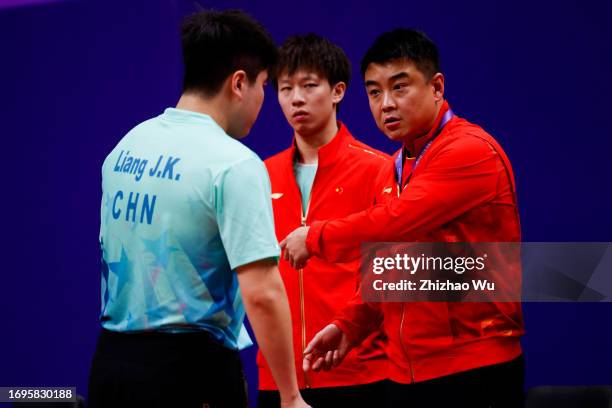 Coach Wang Hao talks to Liang Jingkun of China during the 19th Asian Games Table Tennis Men's Team Preliminary -Group A between China and Vietnam at...