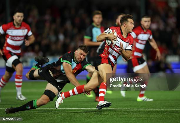 Lloyd Evans of Gloucester Rugby runs past Stephan Lewies of Harlequins during their Premiership Rugby Cup match at Kingsholm Stadium on September 22,...