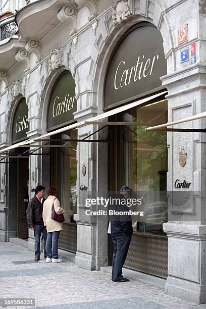 Pedestrians look at the window displays of a Cartier luxury store, a unit of Cie. Richemont SA, in Prague, Czech Republic, on Monday, May 27, 2013....