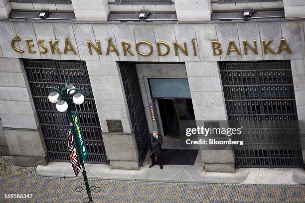 Man speaks on a cellphone outside the entrance to the headquarters of the Czech central bank in Prague, Czech Republic, on Monday, May 27, 2013....