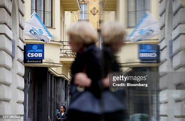 Pedestrian is reflected in glass outside a branch of CSOB AB, the Czech unit of KBC Groep NV bank, in Prague, Czech Republic, on Monday, May 27,...