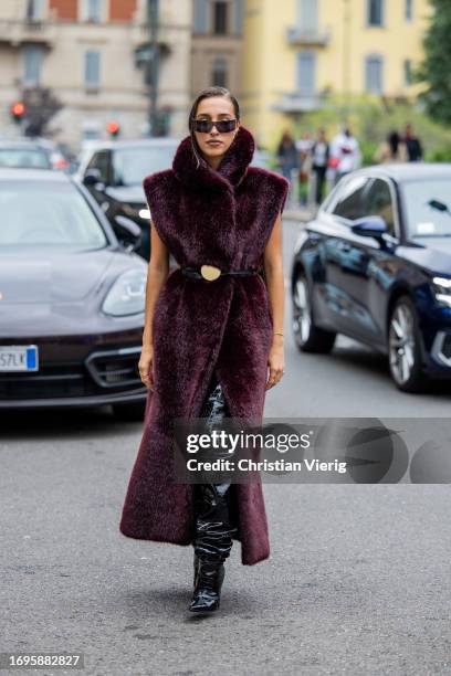 Ginevra Mavilla wears belted burgundy teddy fur coat, black over knees boots, bag outside Philosophy during the Milan Fashion Week - Womenswear...