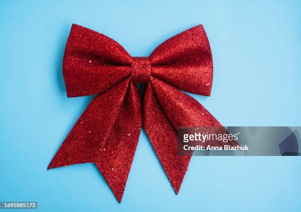 big christmas red bow decoration on blue background - bow tie stock-fotos und bilder