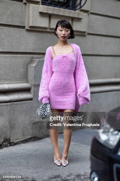 Lin Lin is seen wearing a black and white printed bag, silver printed earrings, a pink dress embellished with a bow and embroidered with silver...