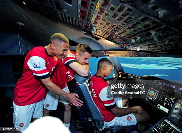 Kieran Gibbs, Carl Jenkinson and Alex Oxlade-Chamberlain of Arsenal sit in an Airline Simulator during the Arsenal Emirates Airline Simulator...