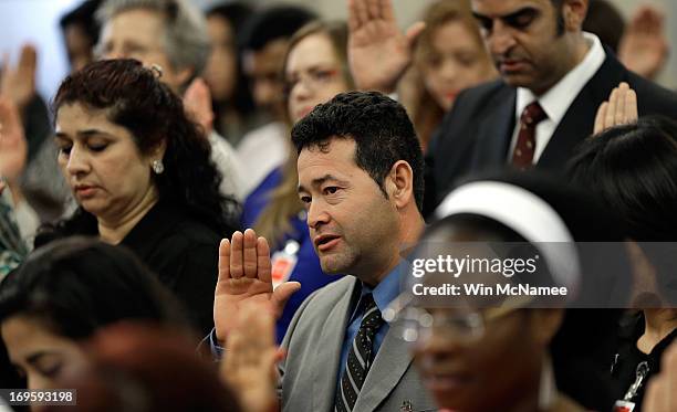 Recently naturalized U.S. Citizens take the Oath of Citizenship during a naturalization ceremony at the U.S. Department of Justice May 28, 2013 in...