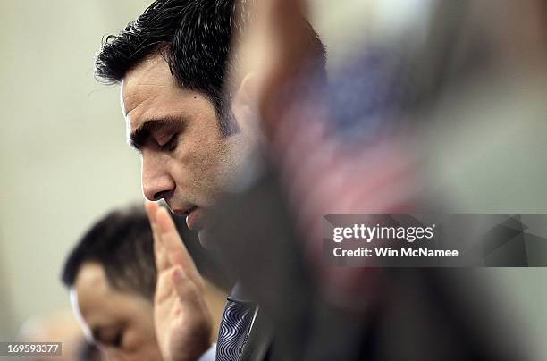 Recently naturalized U.S. Citizens take the Oath of Citizenship during a naturalization ceremony at the U.S. Department of Justice May 28, 2013 in...