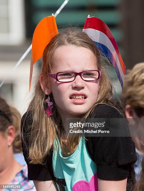 Girl watches King Willem-Alexander and Queen Maxima of The Netherlands during their one day visit to Groningen and Drenthe provinces on May 28, 2013...