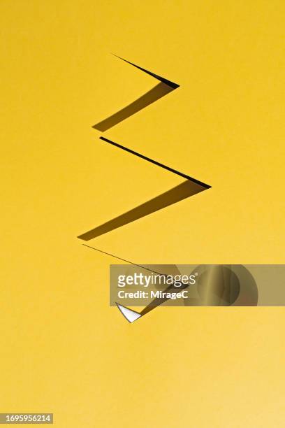 sharp knife cutting a zigzag line on yellow paper - utility knife stockfoto's en -beelden