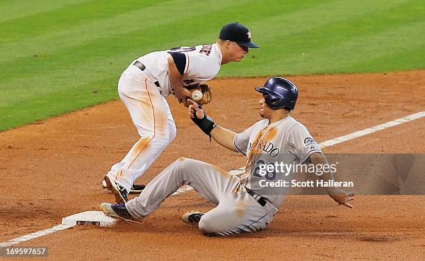 Nolan Arenado of the Colorado Rockies is safe at third base during the third inning under the tag of Matt Dominguez of the Houston Astros at Minute...