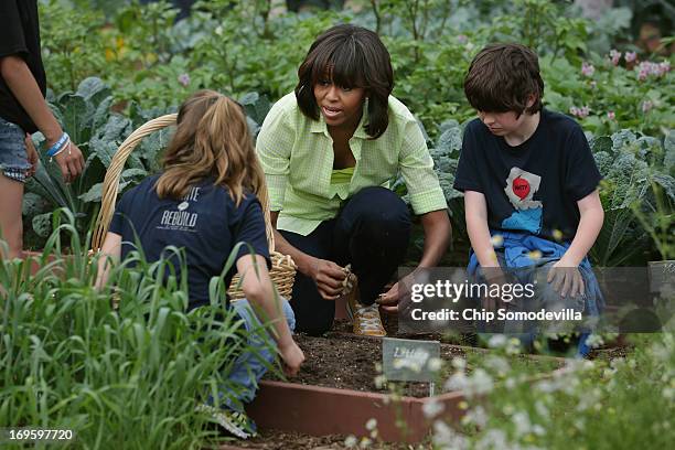 First lady Michelle Obama harvests lettuce and other vegetables from the White House Kitchen Garden's summer crop with children from Union Beach...