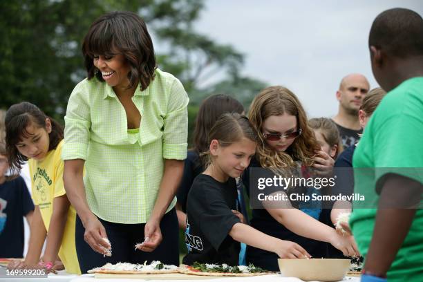 First lady Michelle Obama prepare flat bread pizza with vegetables harvested from the White House Kitchen Garden with children from two New Jersey...