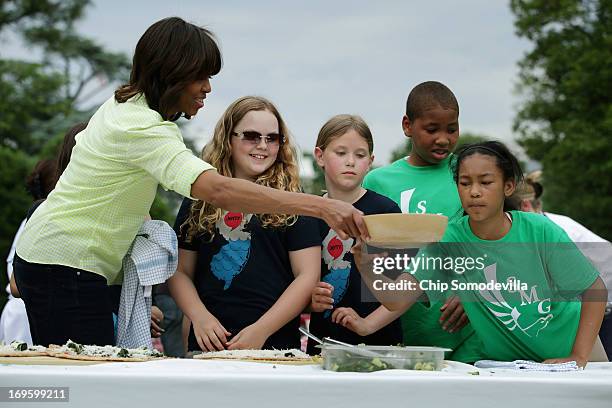 First lady Michelle Obama prepare flat bread pizza with vegetables harvested from the White House Kitchen Garden with children from two New Jersey...