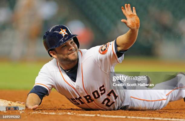 Jose Altuve of the Houston Astros dives back into first base during the fourth inning against the Colorado Rockies at Minute Maid Park on May 28,...