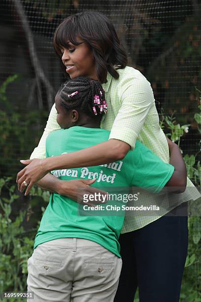 First lady Michelle Obama gets a hug while harvesting the summer crop from the White House Kitchen Garden with children from two New Jersey...