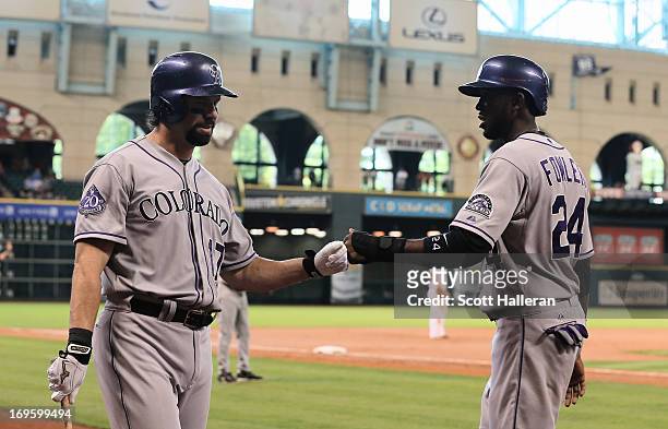 Dexter Fowler of the Colorado Rockies is greeted by Todd Helton after scoring a run in the first inning against the Houston Astros at Minute Maid...