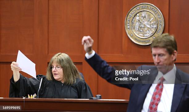 Defense attorney Mark O'Mara hands Circuit Judge Debra Nelson a document during a pre-trial hearing May 28, 2013 in Sanford, Florida. George...