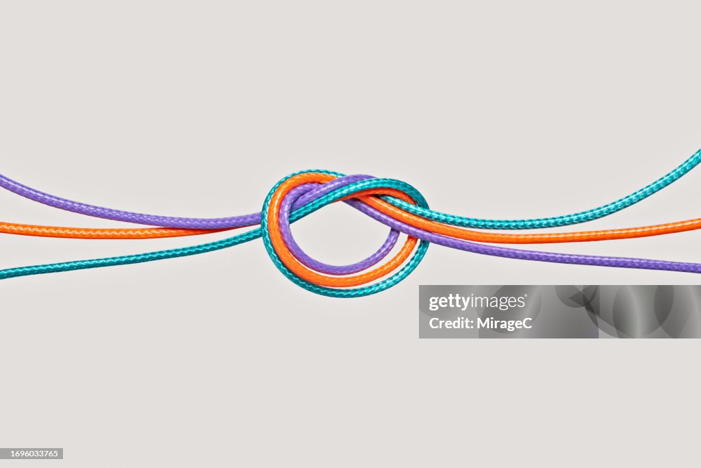 Four Ropes Together Colorful Ropes Knotted Together On Beige Background High-Res Stock ...