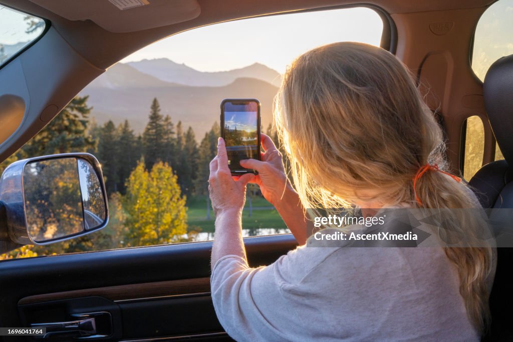 Mature woman takes photo from vehicle