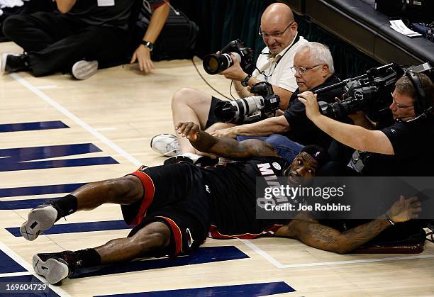 LeBron James of the Miami Heat falls into photographers and a videorapher during Game Four of the Eastern Conference Finals of the 2013 NBA Playoffs...