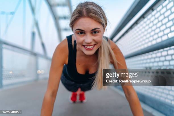 smiling woman doing push-ups - push ups stock pictures, royalty-free photos & images