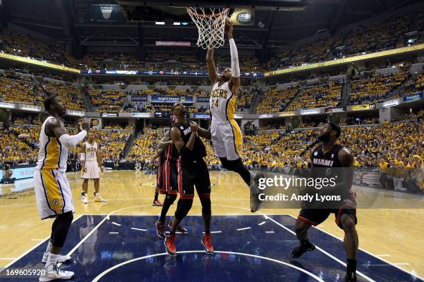 Paul George of the Indiana Pacers drives for a dunk attempt against Chris Bosh and LeBron James of the Miami Heat during Game Four of the Eastern...