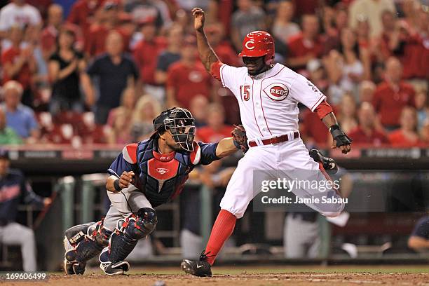 Catcher Carlos Santana of the Cleveland Indians tags out Derrick Robinson of the Cincinnati Reds at home plate in the seventh inning at Great...