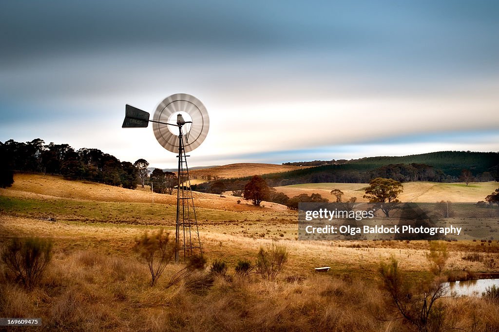 Windmill and rolling hills, charming countryside