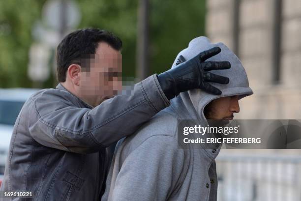 The suspected Alexandre Dhaussy perpetrator of the May 26, 2013 attack on a soldier the La Defense business district, is escorted by a policeman of...