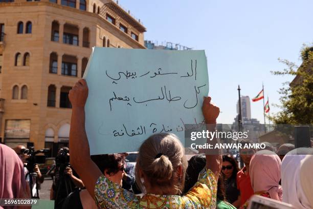 School teacher lifts a placard during a sit in outside the Lebanese parliament in Beirut's downtown district on September 18, 2023. Lack of funding...