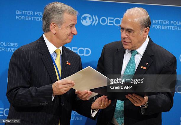 Chile Minister of Finance Felipe Larrain is flanked by OECD General Secretary Angel Gurria after signing a letter of intention to sign an OECD...