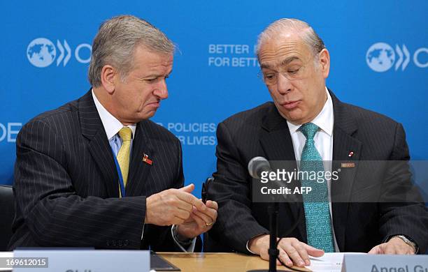 Chile Minister of Finance Felipe Larrain and OECD General Secretary Angel Gurria joke about the pen before the signing by Chile of a letter of...