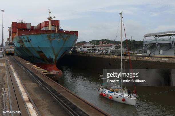 The container ship Maersk Bogor passes through the Miraflores locks with a small boat while transiting the Panama Canal on September 22, 2023 in...