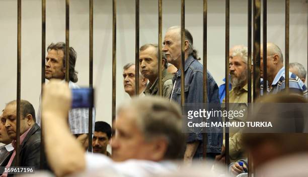 Prisoners from Belarus, Russia and Ukraine stand behind bars during their appeal trial as they are accused of serving as mercenaries for the ousted...