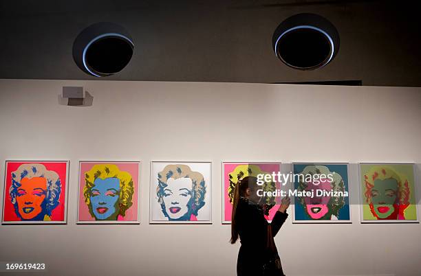 Visitor takes a photo of collection by Andy Warhol during a press preview of the 'Marilyn' exhibition at Prague Castle on May 29, 2013 in Prague,...