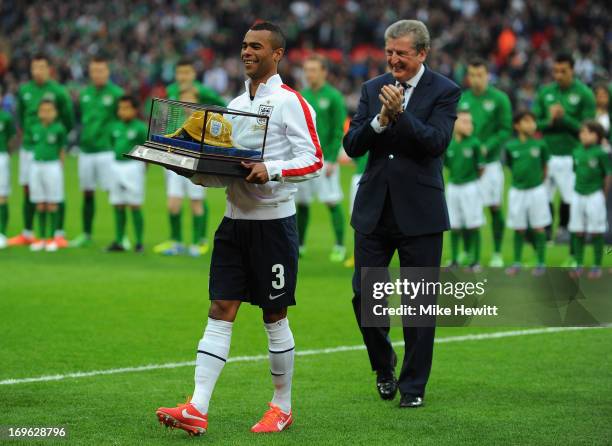 Captain Ashley Cole of England is honoured with his 100th cap as Roy Hodgson manager of England looks on prior to the International Friendly match...