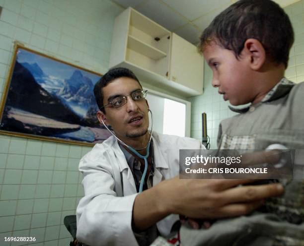 Dr. Harith al-Hossuna examines a patient at the Nasiriyah General Hospital, 18 April 2003. AFP PHOTO/Cris BOURONCLE