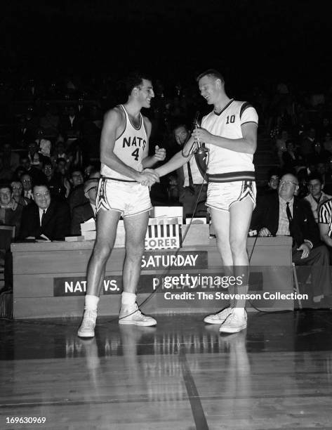 Dolph Schayes of the Syracuse Nationals and Red Kerr greet each other against the New York Knicks circa 1962 at the Onondaga War Memorial in...