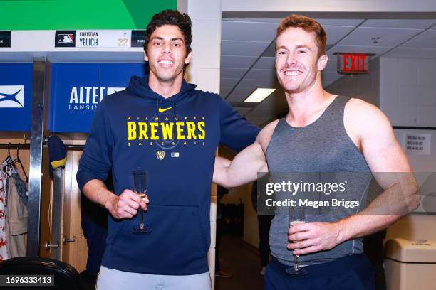 Christian Yelich and Mark Canha of the Milwaukee Brewers celebrate in the clubhouse after defeating the Miami Marlins to clinch a spot in the...